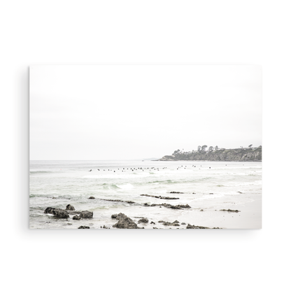 Landscape coastal photography of Salt Creek Beach with dark rocks on the shore and numerous surfers in the ocean. A neutral ocean print perfect for beach house decor. Photograph in minimalist mock up.