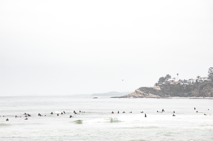 Landscape surf wall decor showing many surfers waiting for waves in the ocean at Salt Creek Beach, with a distant cliffside. This print captures the surf vibes of Southern California. 