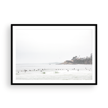 Landscape surf wall decor showing many surfers waiting for waves in the ocean at Salt Creek Beach, with a distant cliffside. This print captures the surf vibes of Southern California. Photograph in minimalist mock up.