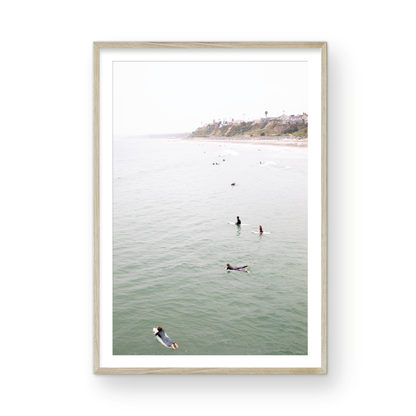 Vertical surf print of surfers floating in the ocean waves at a Southern California beach, with a distant coastline. This image captures surfing art and a minimalist surf vibe. Photograph in minimalist mock up.