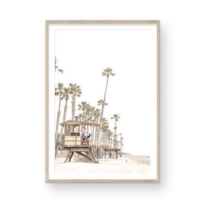 A landscape coastal photography view of San Clemente State Beach in Southern California, featuring a row of tall palm trees, a lifeguard tower, and people enjoying the calm beach. This vertical image evokes Summer Vibes Wall Art and tropical beach print aesthetics. Photograph in minimalist mock up.
