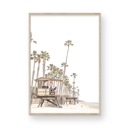 A landscape coastal photography view of San Clemente State Beach in Southern California, featuring a row of tall palm trees, a lifeguard tower, and people enjoying the calm beach. This vertical image evokes Summer Vibes Wall Art and tropical beach print aesthetics. Photograph in minimalist mock up.