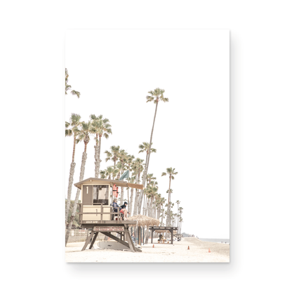 A landscape coastal photography view of San Clemente State Beach in Southern California, featuring a row of tall palm trees, a lifeguard tower, and people enjoying the calm beach. This vertical image evokes Summer Vibes Wall Art and tropical beach print aesthetics. Photograph in minimalist mock up.