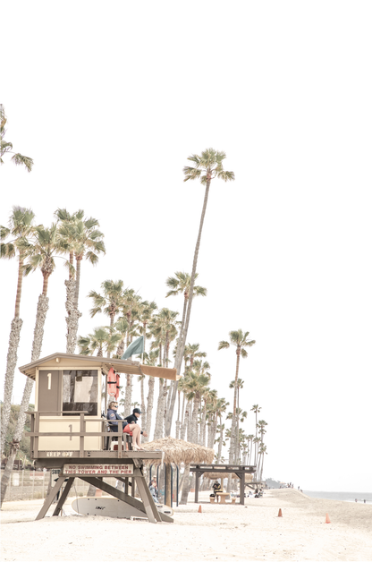 A landscape coastal photography view of San Clemente State Beach in Southern California, featuring a row of tall palm trees, a lifeguard tower, and people enjoying the calm beach. This vertical image evokes Summer Vibes Wall Art and tropical beach print aesthetics.