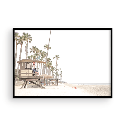 A wide landscape coastal photography view of San Clemente State Beach in Southern California, featuring a row of tall palm trees, a lifeguard tower, and people enjoying the calm beach. This image evokes Summer Vibes Wall Art and tropical beach print aesthetics. Photograph in minimalist mock up.