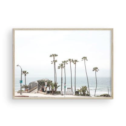 Landscape coastal photography of T-Street Beach in San Clemente, with tall palm trees and a unique pier structure leading to the ocean. A perfect horizontal California coast print. Photograph in minimalist mock up