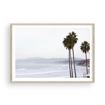 Landscape San Diego beach print showing a seascape with gentle ocean waves in the water and palm trees in the foreground. Photograph in minimalist mock up.