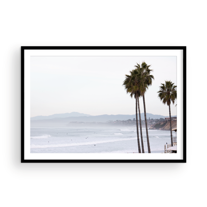 Landscape San Diego beach print showing a seascape with gentle ocean waves in the water and palm trees in the foreground. Photograph in minimalist mock up.