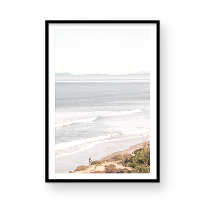 Minimalist ocean print of ocean waves with surfers in the distance and a sandy hillside in the foreground. Photograph in minimalist mock up.
