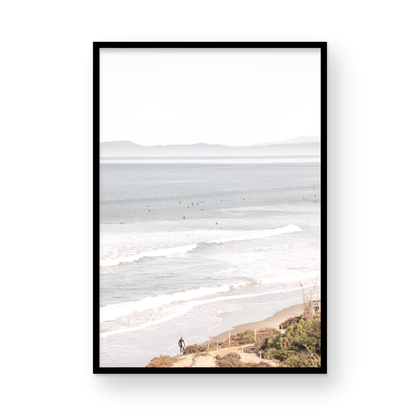 Minimalist ocean print of ocean waves with surfers in the distance and a sandy hillside in the foreground. Photograph in minimalist mock up.