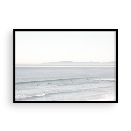 Coastal photography featuring a calm ocean scene with gentle waves and a hazy horizon line, predominantly in blue and white tones. Photograph in minimalist mock up.