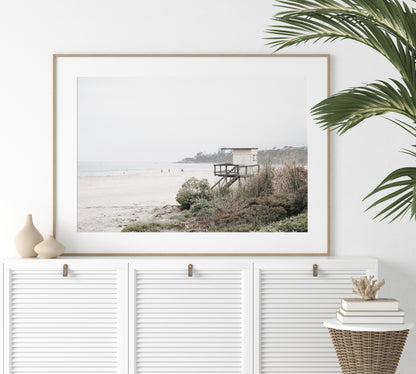 Landscape beach photography of Salt Creek Beach, with lifeguard tower SC 3 in the foreground, and many people enjoying the beach and ocean in the distance. A beach vibes print. Photograph in minimalist mock up.