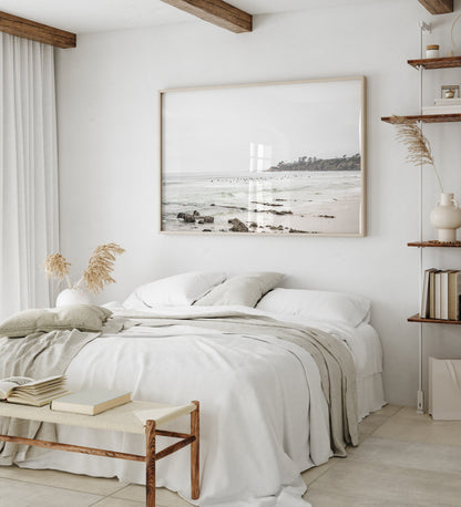 Landscape coastal photography of Salt Creek Beach with dark rocks on the shore and numerous surfers in the ocean. A neutral ocean print perfect for beach house decor. Photograph in minimalist mock up.