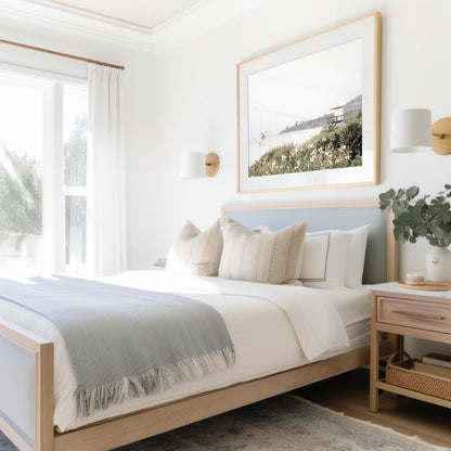 Landscape coastal photography of Salt Creek Beach Park, featuring a lifeguard tower and white flowers in the foreground, with distant cliffs. This calm beach print offers a serene coastal vibe. Photograph in minimalist mock up.