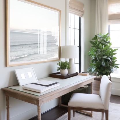 Coastal photography featuring a calm ocean scene with gentle waves and a hazy horizon line, predominantly in blue and white tones. Photograph in minimalist mock up.