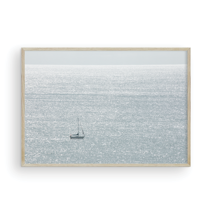 Large minimalist ocean print showing a smooth seascape with gentle ocean waves meeting a clear horizon line, one single sail boat in the distance. This calm nautical print provides a serene view in Dana Point, San Diego, California. Photograph in minimalist mock up.