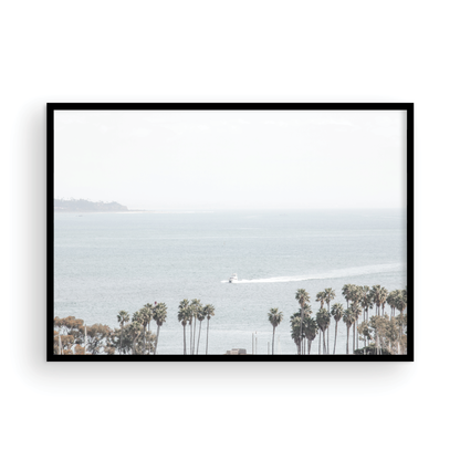 Landscape San Diego beach print showing a seascape with a boat gliding on the water with palm trees in the foreground. Photograph in minimalist mock up.