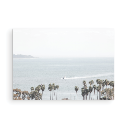 Landscape San Diego beach print showing a seascape with a boat gliding on the water with palm trees in the foreground. Photograph in minimalist mock up.