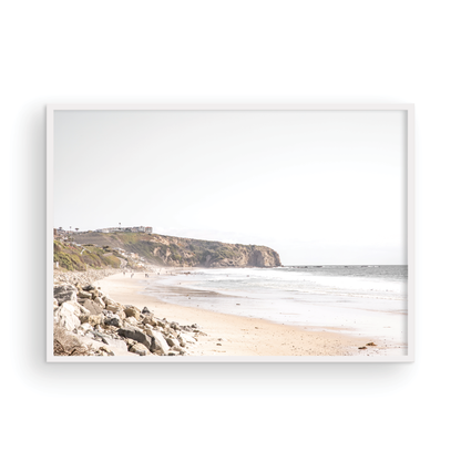 Minimalist ocean print of ocean waves with beach goers in the distance and large  sandy cliffs in the distance overlooking the seascape. Photograph in minimalist mock up.