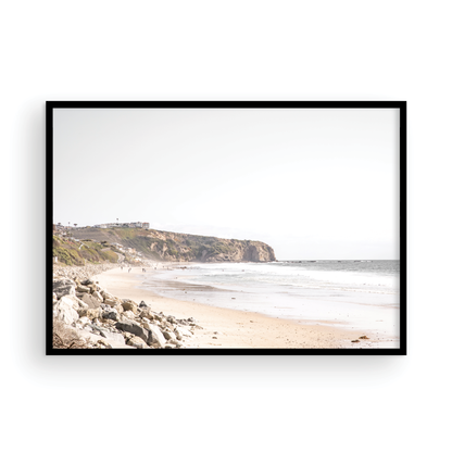 Minimalist ocean print of ocean waves with beach goers in the distance and large  sandy cliffs in the distance overlooking the seascape. Photograph in minimalist mock up.