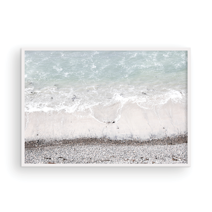 Horizontal surf print of a rocky beach next to foamy ocean waves. This surfing art captures a unique coastline. Photograph in minimalist mock up.