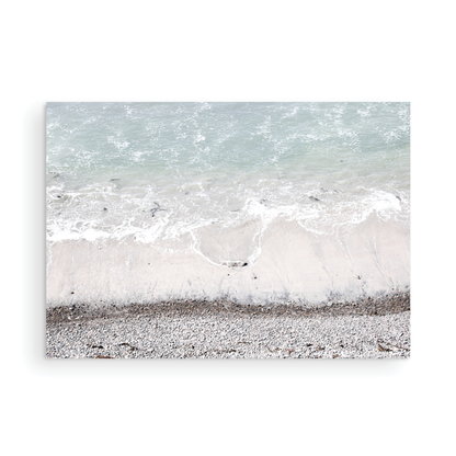 Horizontal surf print of a rocky beach next to foamy ocean waves. This surfing art captures a unique coastline. Photograph in minimalist mock up.