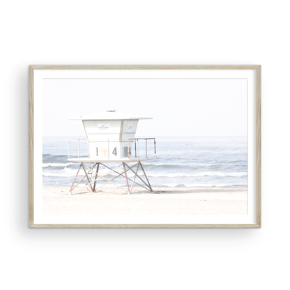 A horizontal beach art close-up of a pale lifeguard tower (14), with ocean waves in the distance, on a San Diego Beach. Photograph in minimalist mock up.