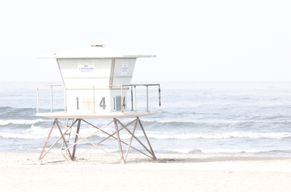 A horizontal beach art close-up of a pale lifeguard tower (14), with ocean waves in the distance, on a San Diego Beach. Photograph in minimalist mock up.