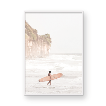 Vertical surf art print of a lone surfer carrying a surfboard, walking on a rocky, foggy shoreline at Moonlight State Beach with a lifeguard tower and cliff in the background. Photograph in minimalist mock up.