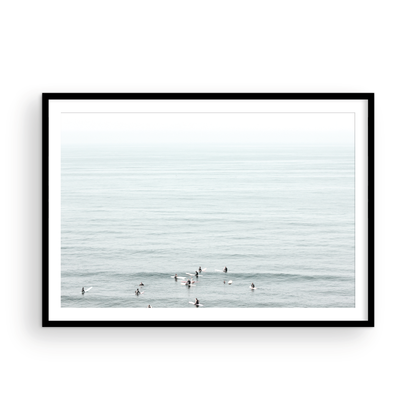 Horizontal surf art showing multiple surfers waiting in the calm ocean water for waves, with a hazy Southern California coastline in the distance. This minimalist surf print captures authentic surf vibes. Photograph in minimalist mock up.