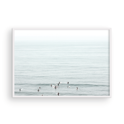 Horizontal surf art showing multiple surfers waiting in the calm ocean water for waves, with a hazy Southern California coastline in the distance. This minimalist surf print captures authentic surf vibes. Photograph in minimalist mock up.