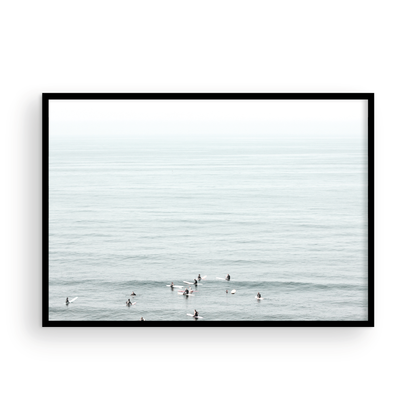 Horizontal surf art showing multiple surfers waiting in the calm ocean water for waves, with a hazy Southern California coastline in the distance. This minimalist surf print captures authentic surf vibes. Photograph in minimalist mock up.