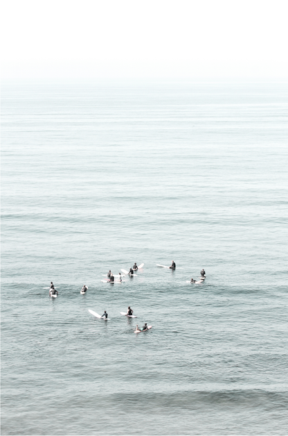 Vertical surf art showing multiple surfers waiting in the calm ocean water for waves, with a hazy Southern California coastline in the distance. This minimalist surf print captures authentic surf vibes. 