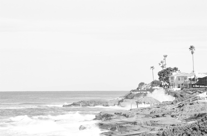 Fine art of WindanSea Beach, La Jolla California horizontal landscape black and white print by Southern California photographer Kim Dybczak of Salt Creek Prints, featuring a powerful waves crashing against the rocky shore of California coast. Beach homes and palm trees sit atop the cliffside, with stairs leading down to a sheltered area. 