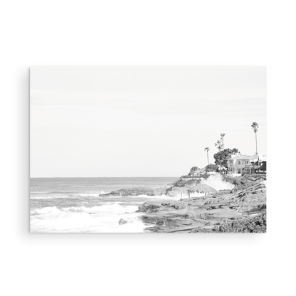 Fine art of WindanSea Beach, La Jolla California horizontal landscape black and white print by Southern California photographer Kim Dybczak of Salt Creek Prints, featuring a powerful waves crashing against the rocky shore of California coast. Beach homes and palm trees sit atop the cliffside, with stairs leading down to a sheltered area. Photograph in minimalist mock up