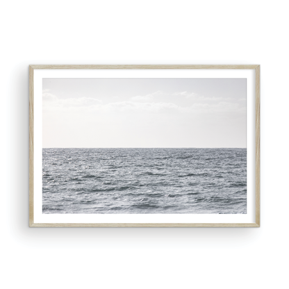 Minimalist ocean print of gentle ocean waves rolling at Moonlight Beach, San Diego, under a bright, soft sky. This calm beach print provides a serene seascape. Photograph in minimalist mock up