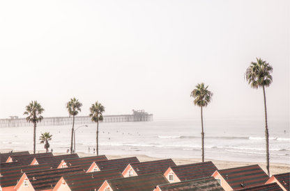 Landscape coastal photography of Oceanside, California, featuring a row of charming beachfront houses with the Oceanside Pier and ocean in the background.