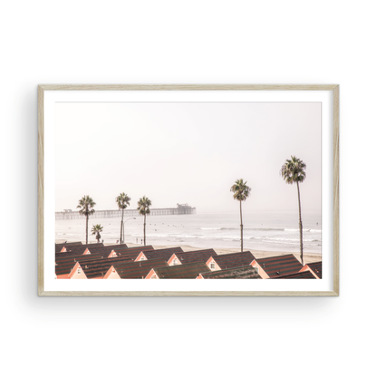 Landscape coastal photography of Oceanside, California, featuring a row of charming beachfront houses with the Oceanside Pier and ocean in the background.  Photograph in minimalist mock up.