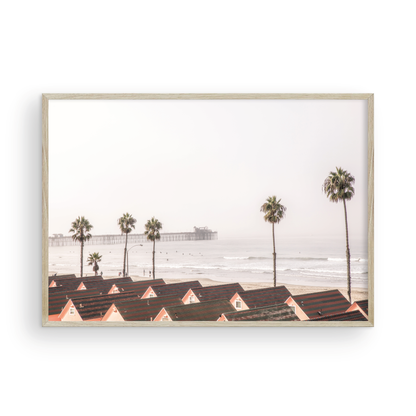 Landscape coastal photography of Oceanside, California, featuring a row of charming beachfront houses with the Oceanside Pier and ocean in the background.  Photograph in minimalist mock up.