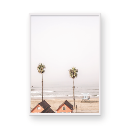 Vertical coastal photography of Oceanside, California, showing beachfront houses and a lifeguard tower with two prominent palm trees overlooking the ocean. A minimalist surf print. Photograph in minimalist mock up.