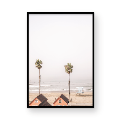 Vertical coastal photography of Oceanside, California, showing beachfront houses and a lifeguard tower with two prominent palm trees overlooking the ocean. A minimalist surf print. Photograph in minimalist mock up.