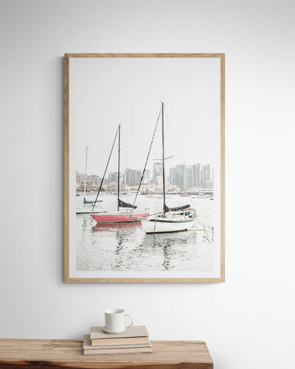 A vertical San Diego print showcasing numerous sailboats in San Diego Harbor with the city skyline in the background. This modern coastal print embodies the Southern California coastal photography, perfect for a large beach wall art. Photograph in minimalist mock up.