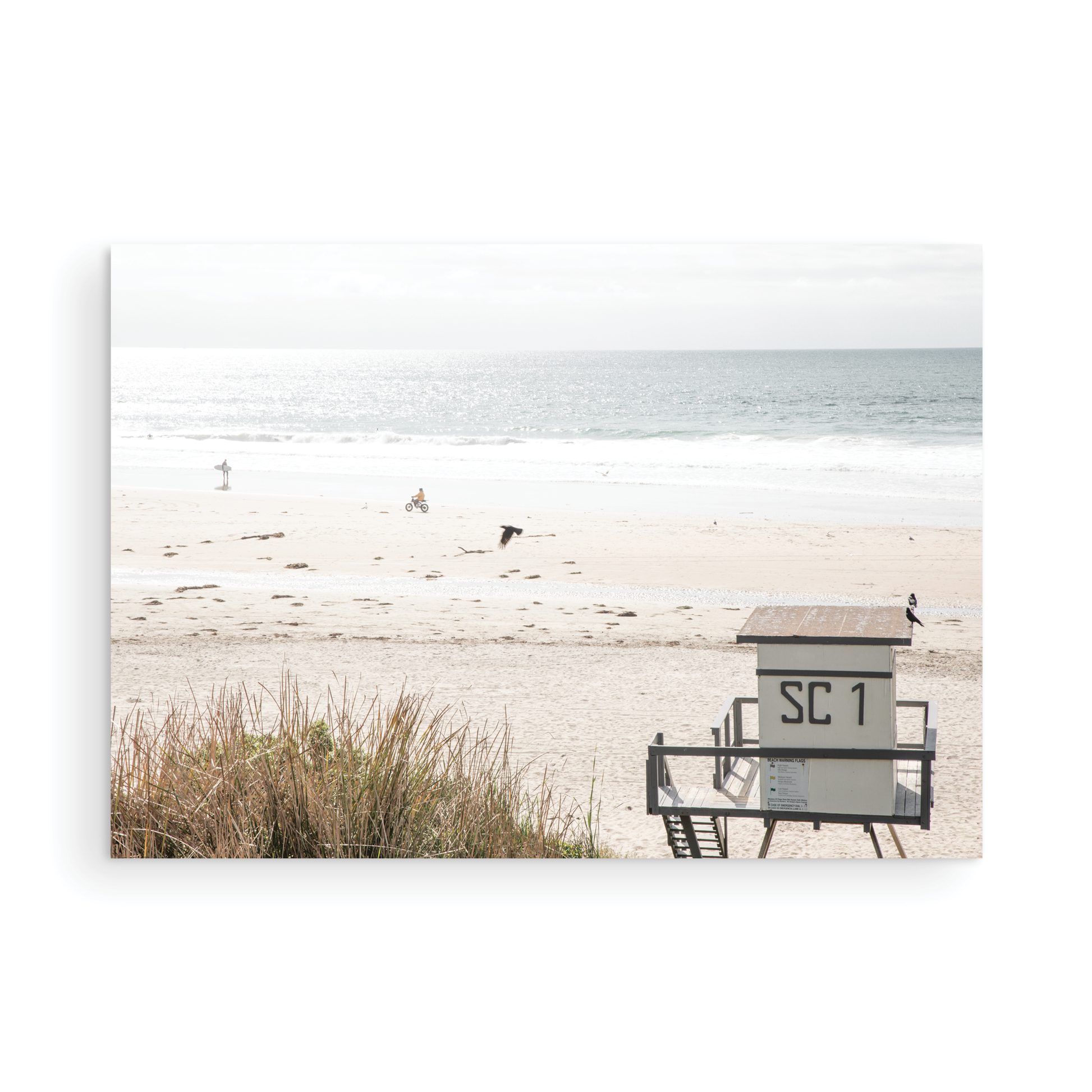 Landscape coastal photography of Salt Creek Beach Park featuring a lifeguard tower (SC 1) on the sand, with distant figures and ocean waves. This beachscape print has a calming vibe. Photograph in minimalist mock up.