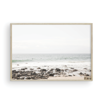 Landscape coastal photography of Salt Creek Beach with dark rocks on the shore and numerous surfers in the ocean. A neutral ocean print perfect for beach house decor. Photograph in minimalist mock up.