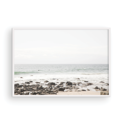 Landscape coastal photography of Salt Creek Beach with dark rocks on the shore and numerous surfers in the ocean. A neutral ocean print perfect for beach house decor. Photograph in minimalist mock up.