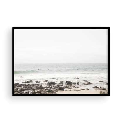 Landscape coastal photography of Salt Creek Beach with dark rocks on the shore and numerous surfers in the ocean. A neutral ocean print perfect for beach house decor. Photograph in minimalist mock up.