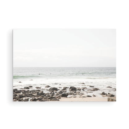 Landscape coastal photography of Salt Creek Beach with dark rocks on the shore and numerous surfers in the ocean. A neutral ocean print perfect for beach house decor. Photograph in minimalist mock up.
