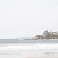 Landscape surf wall decor featuring surfers in the ocean near Salt Creek Beach, with a distant residential coastline and crashing waves. This print captures the surf vibes. 