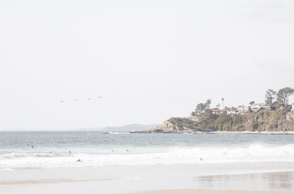 Landscape surf wall decor featuring surfers in the ocean near Salt Creek Beach, with a distant residential coastline and crashing waves. This print captures the surf vibes. 