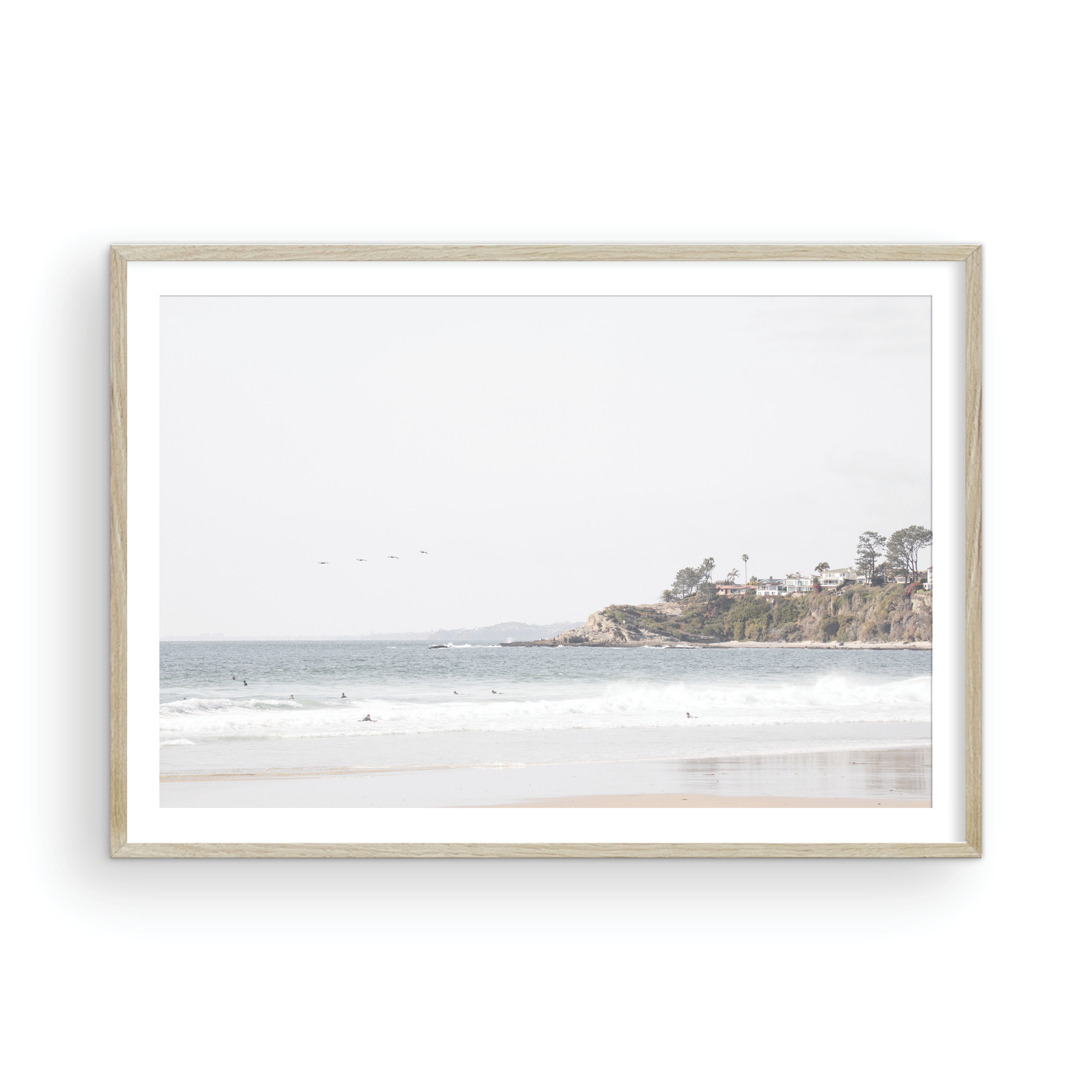 Landscape surf wall decor featuring surfers in the ocean near Salt Creek Beach, with a distant residential coastline and crashing waves. This print captures the surf vibes. Photograph in minimalist mock up.